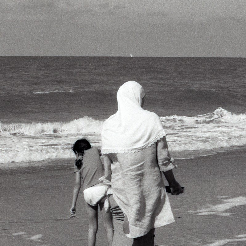 Woman with veil on the beach. 
Femme musulmane voilée sur la plage.